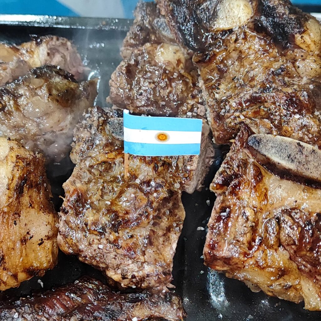 Carne en la parrilla con una bandera argentina