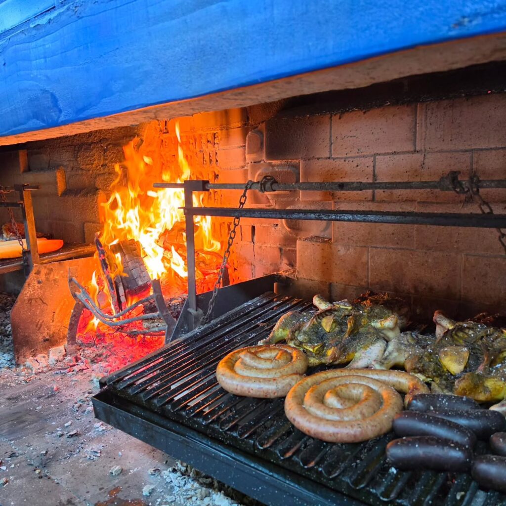 Fuego y alimentos en la parrilla de Asador Xeneize