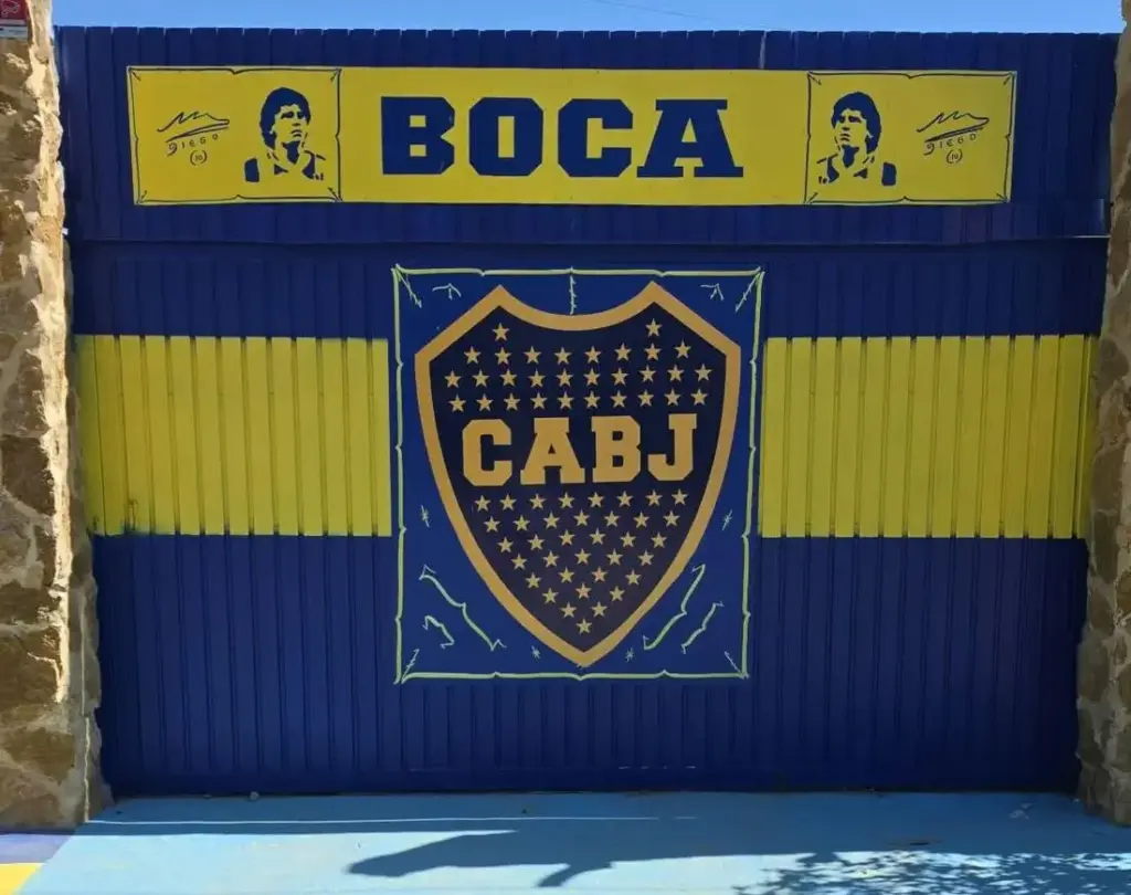 Portón de entrada azul y amarillo de Asador Xeneize